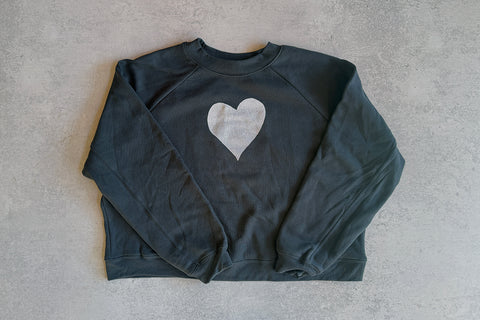Dark gray sweatshirt with a white heart design on a light gray background