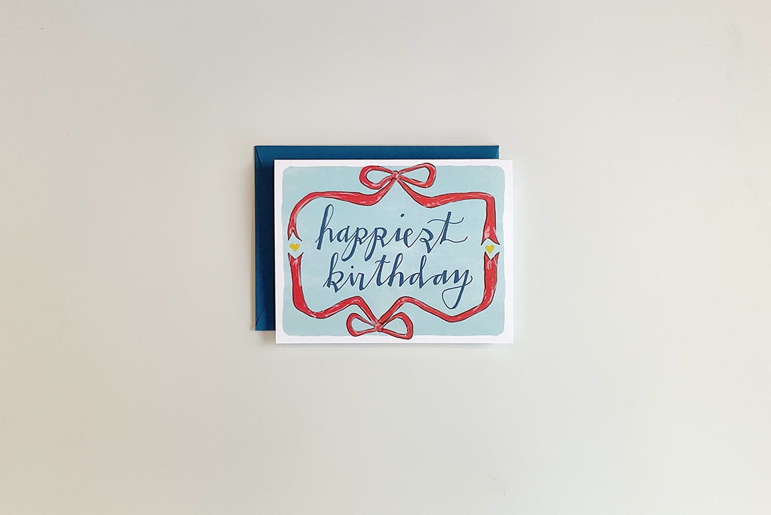 Greeting card with 'happiest birthday' text on a plain background