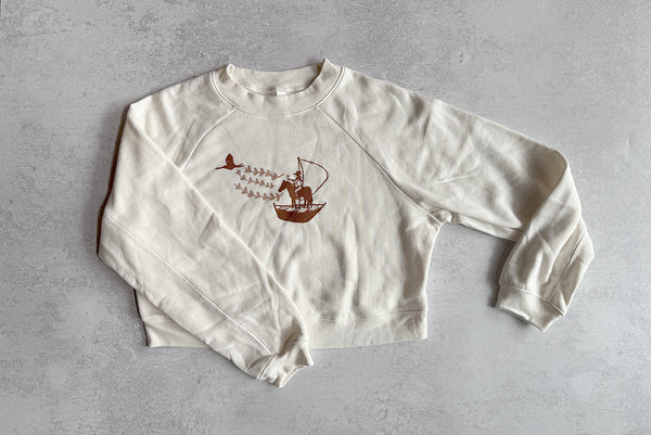 White sweatshirt with brown graphic on a gray background