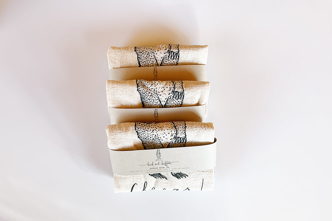 Set of four folded paper towels with black text on a white background